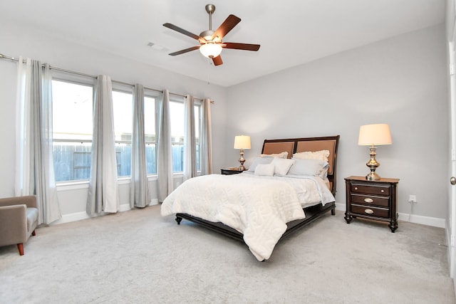 carpeted bedroom featuring multiple windows and ceiling fan