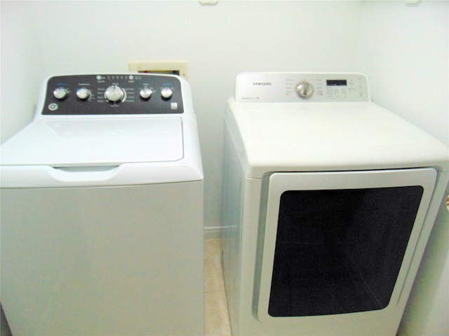 washroom with washer and clothes dryer and tile patterned flooring