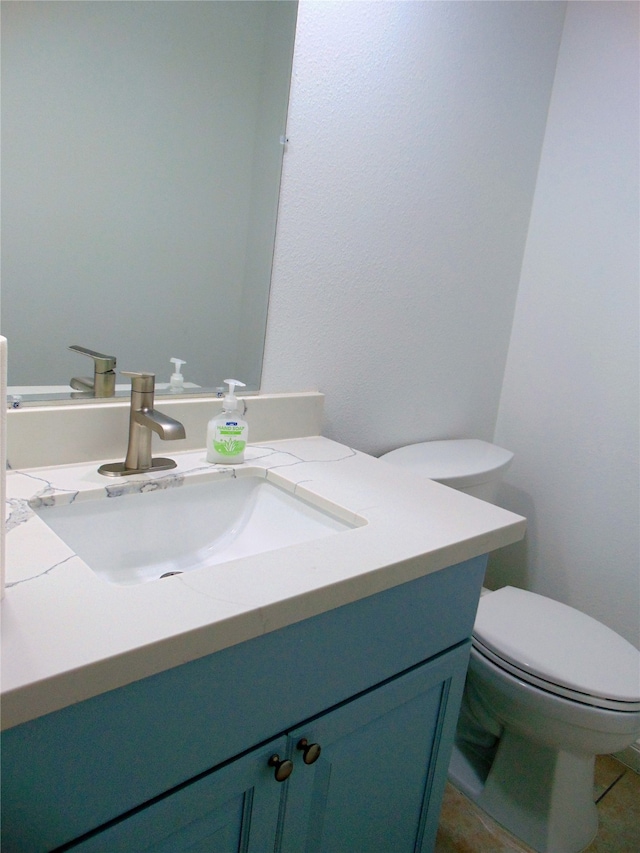 bathroom featuring tile patterned flooring, vanity, and toilet