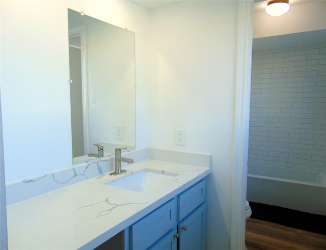 bathroom with toilet, vanity, and hardwood / wood-style flooring