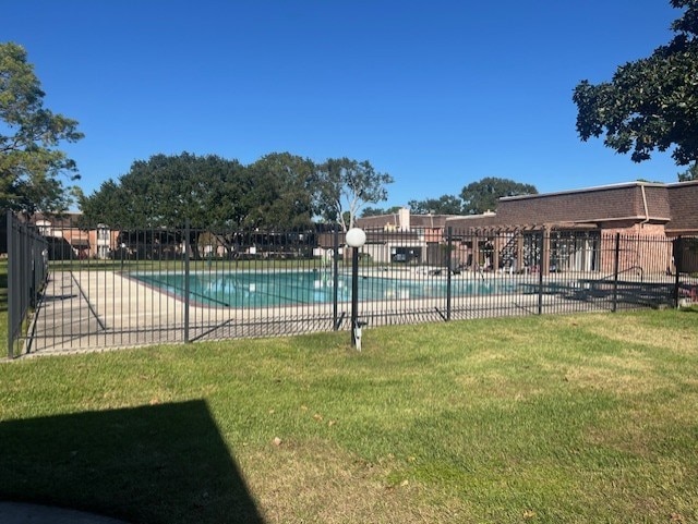 view of pool with a lawn and a patio