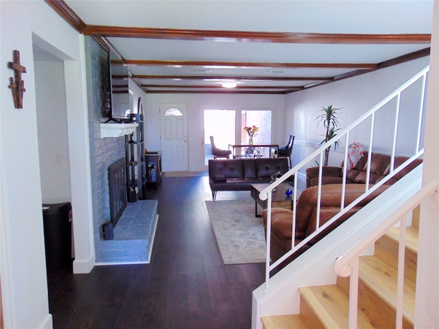 living room with dark hardwood / wood-style floors, beam ceiling, and a fireplace