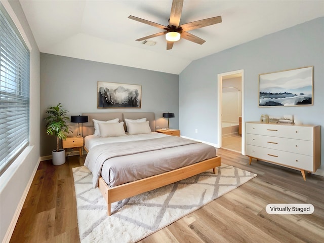 bedroom with hardwood / wood-style flooring, ceiling fan, lofted ceiling, and ensuite bathroom