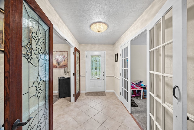 doorway with french doors, a textured ceiling, and light tile patterned flooring