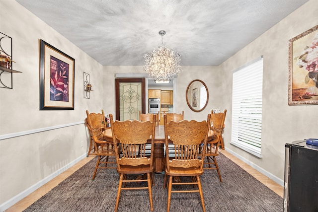 dining room with a notable chandelier and a textured ceiling