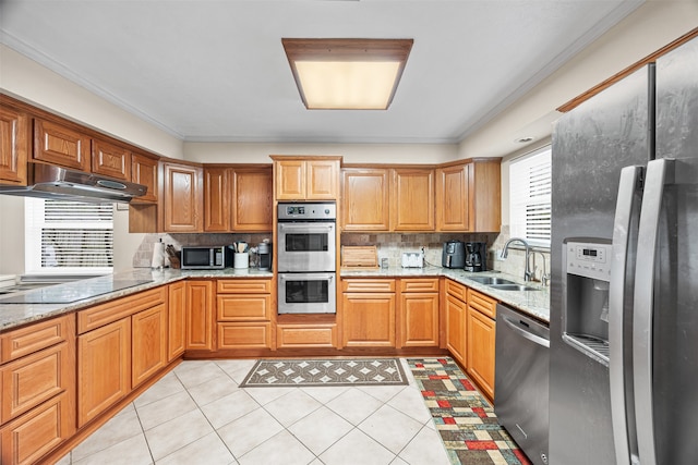 kitchen featuring appliances with stainless steel finishes, plenty of natural light, crown molding, and sink