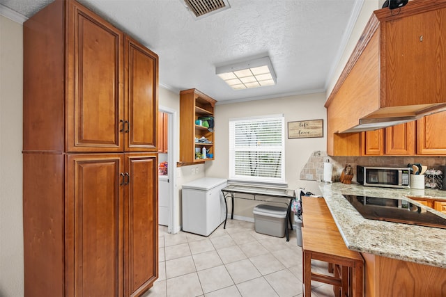 kitchen with black electric stovetop, light stone counters, ornamental molding, and a textured ceiling