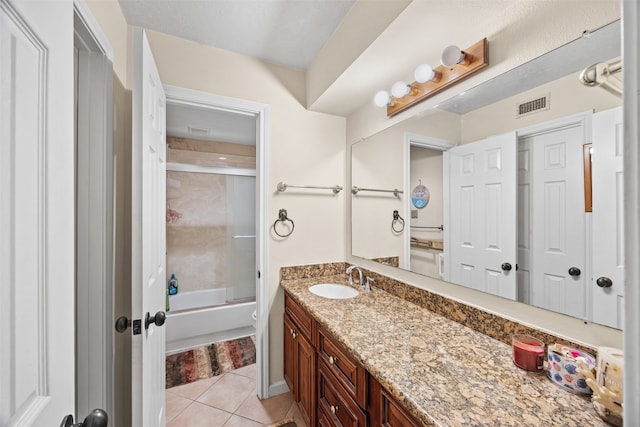 bathroom with tile patterned flooring, vanity, and bath / shower combo with glass door