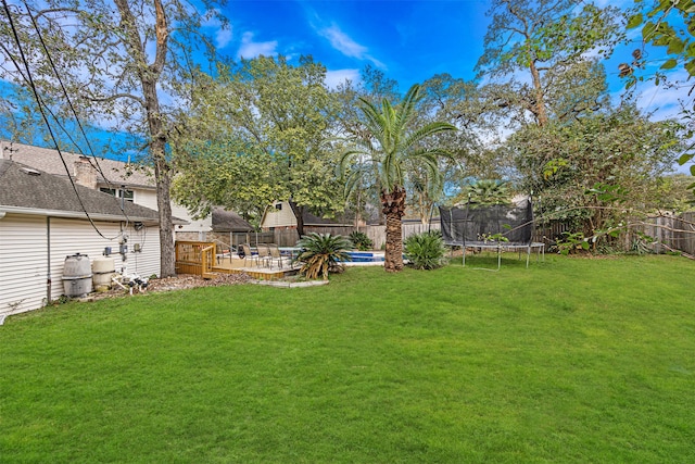 view of yard featuring a trampoline and a pool