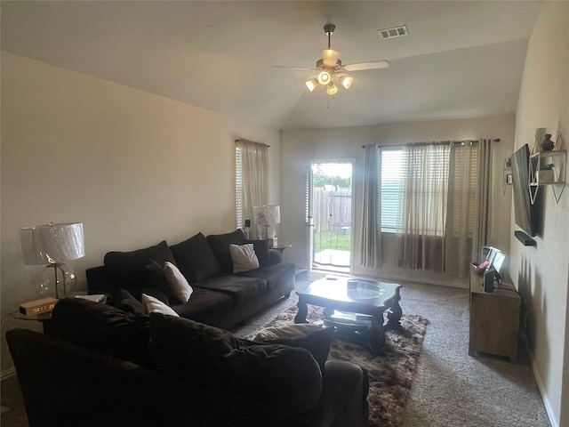 carpeted living room with ceiling fan and vaulted ceiling