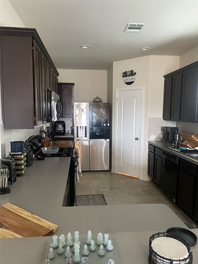 kitchen featuring decorative backsplash, dark brown cabinets, a textured ceiling, and appliances with stainless steel finishes