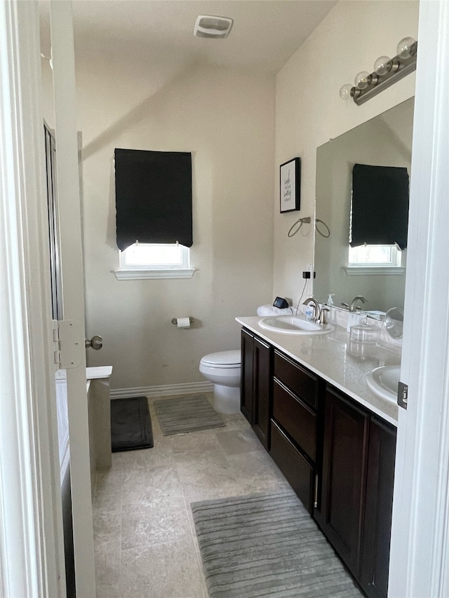 bathroom featuring vanity, toilet, and a wealth of natural light