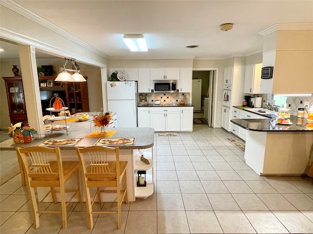 kitchen with white cabinetry, kitchen peninsula, crown molding, white appliances, and decorative backsplash