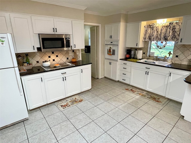 kitchen with white cabinets, white appliances, and tasteful backsplash