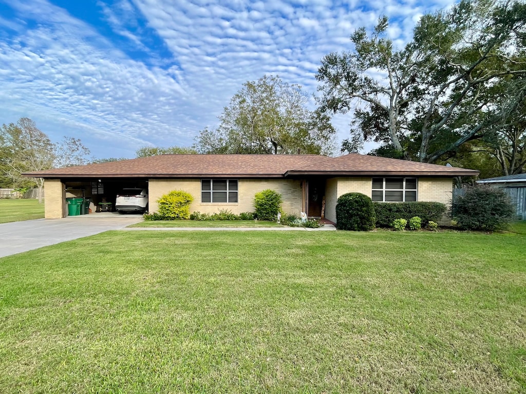 ranch-style house featuring a front lawn and a carport