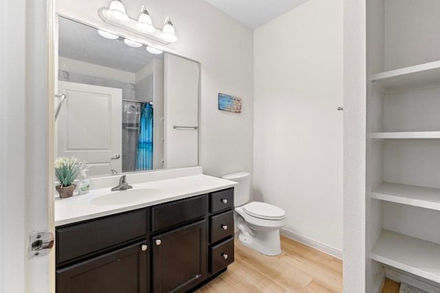 bathroom featuring vanity, toilet, wood-type flooring, and walk in shower