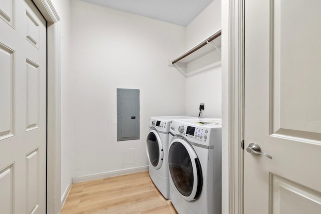 washroom featuring independent washer and dryer, electric panel, and light wood-type flooring