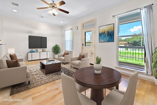 living room featuring light wood-type flooring, ceiling fan, and ornamental molding