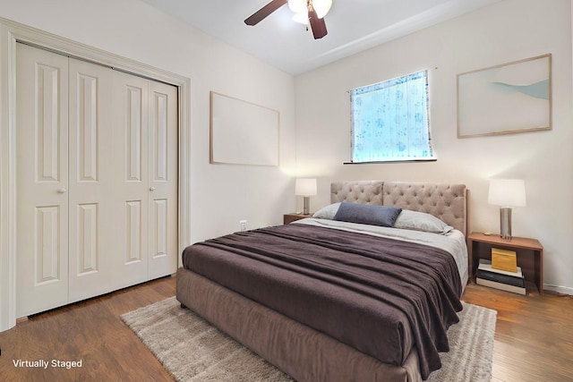 bedroom with ceiling fan, dark wood-type flooring, and a closet