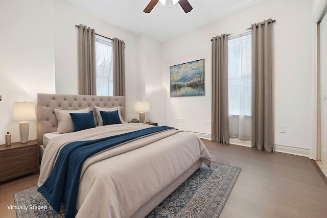 bedroom with hardwood / wood-style floors, multiple windows, and ceiling fan