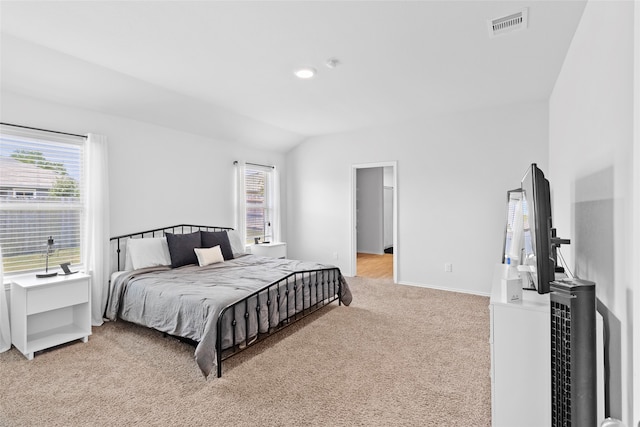 carpeted bedroom with lofted ceiling and multiple windows