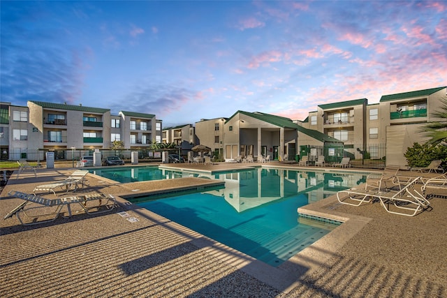 pool at dusk featuring a patio area