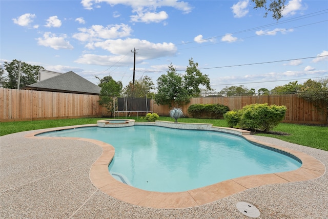 view of swimming pool featuring a trampoline and an in ground hot tub