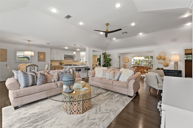 living room with dark hardwood / wood-style flooring, crown molding, ceiling fan, and lofted ceiling