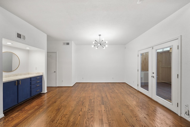 interior space featuring dark hardwood / wood-style flooring, french doors, and a chandelier