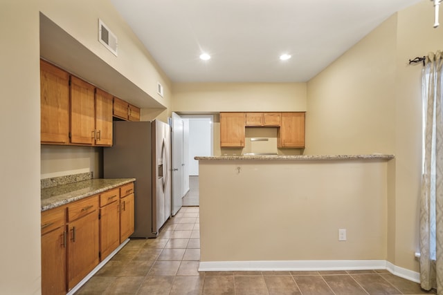 kitchen featuring stainless steel fridge with ice dispenser, light stone counters, and light tile patterned floors