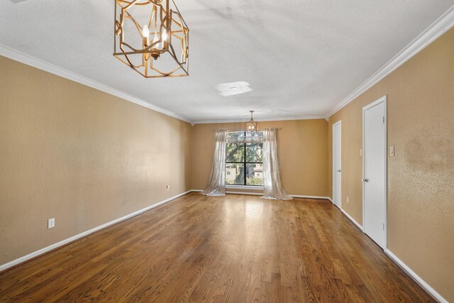 unfurnished dining area with a notable chandelier, wood-type flooring, and ornamental molding