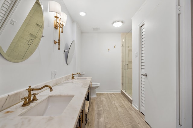 bathroom featuring vanity, crown molding, hardwood / wood-style flooring, toilet, and walk in shower