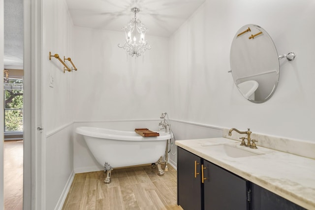2555 Bering Dr Unit 1, Houston, TX 77057 - full bathroom with baseboards, wood finished floors, vanity, a freestanding bath, and an inviting chandelier