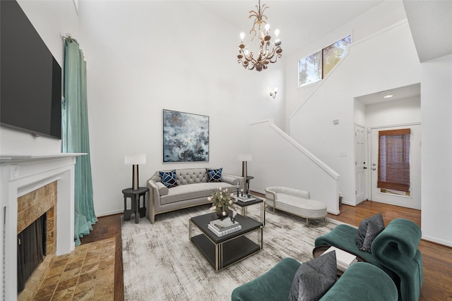 2555 Bering Dr Unit 1, Houston, TX 77057 - living room featuring a notable chandelier, stairway, a fireplace, wood finished floors, and a towering ceiling