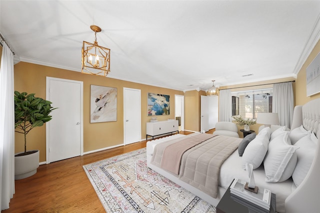 2555 Bering Dr Unit 1, Houston, TX 77057 - bedroom with a notable chandelier, crown molding, and light wood-style flooring