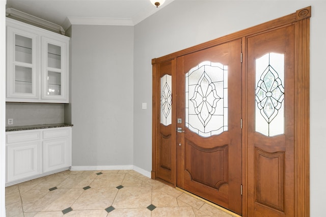 tiled foyer featuring crown molding