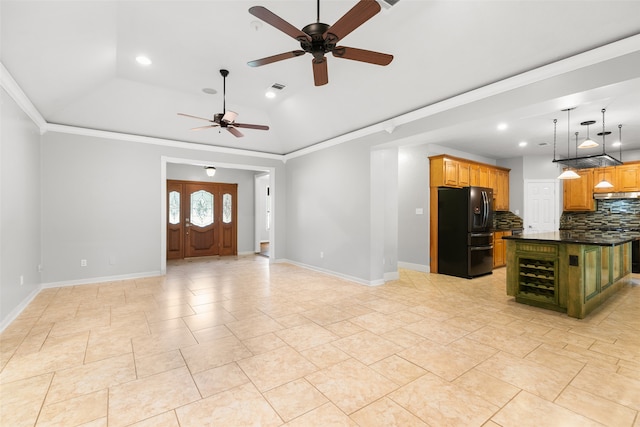 kitchen featuring a center island, black fridge, crown molding, ceiling fan, and tasteful backsplash