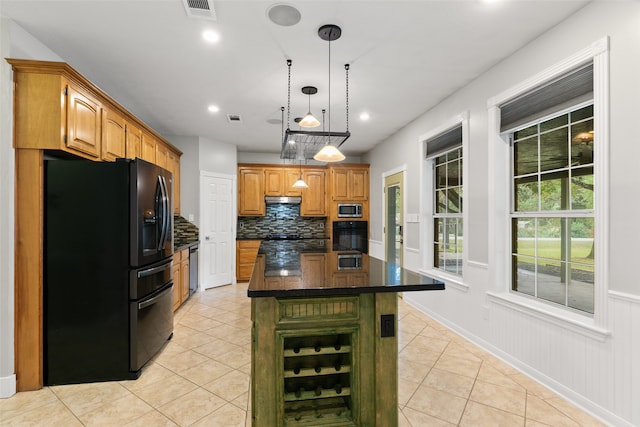 kitchen with decorative backsplash, a kitchen island with sink, black appliances, light tile patterned floors, and hanging light fixtures