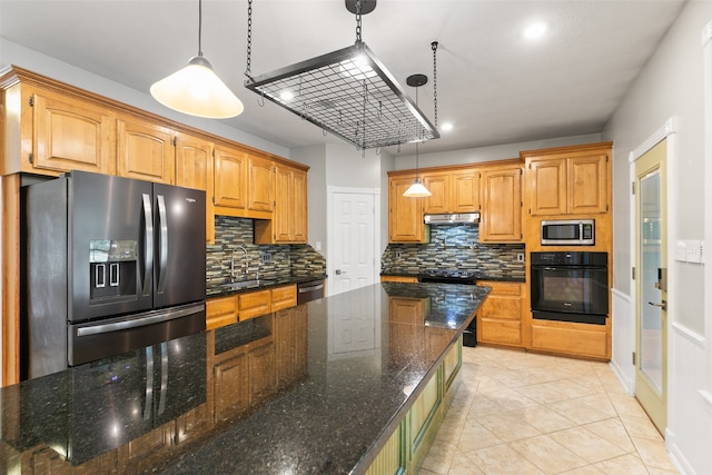 kitchen featuring backsplash, dark stone counters, stainless steel appliances, sink, and pendant lighting