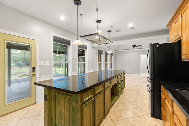 kitchen with black refrigerator, ceiling fan, light tile patterned floors, a center island, and hanging light fixtures