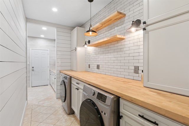 clothes washing area with light tile patterned floors, washer and clothes dryer, cabinet space, and recessed lighting