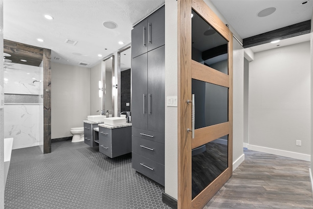 bathroom featuring walk in shower, hardwood / wood-style floors, vanity, and toilet