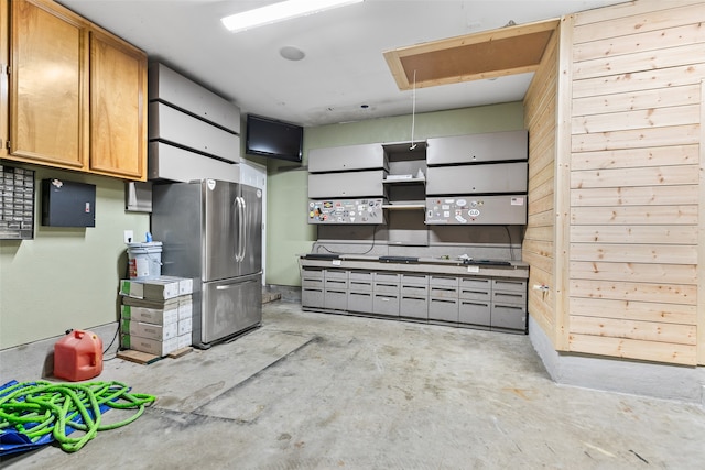 kitchen featuring stainless steel fridge and wood walls