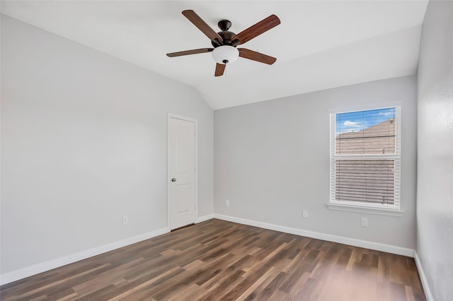 spare room with ceiling fan, lofted ceiling, and dark wood-type flooring