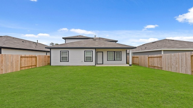 rear view of property with a yard