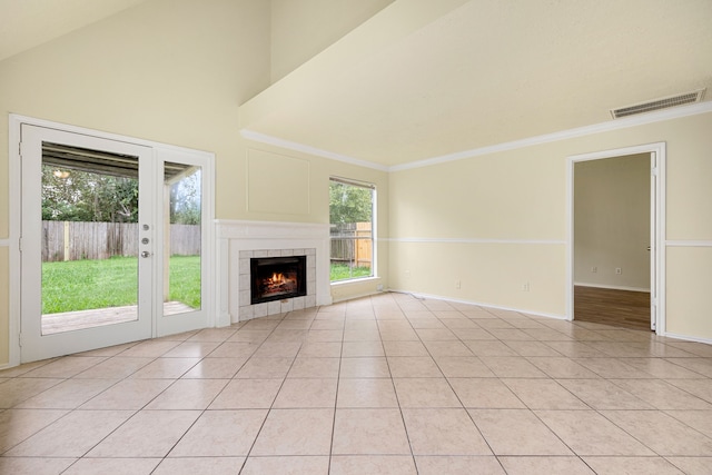 unfurnished living room featuring light tile patterned floors, ornamental molding, and a tiled fireplace