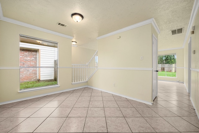 tiled spare room featuring a textured ceiling and crown molding