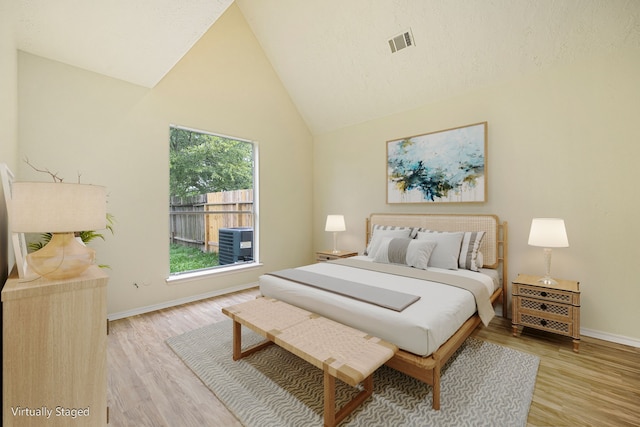 bedroom featuring light hardwood / wood-style flooring and high vaulted ceiling