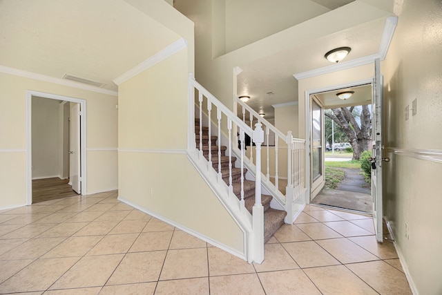 entryway featuring light tile patterned flooring and crown molding