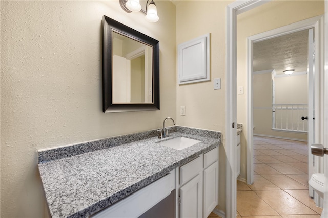 bathroom with tile patterned floors, vanity, and a textured ceiling